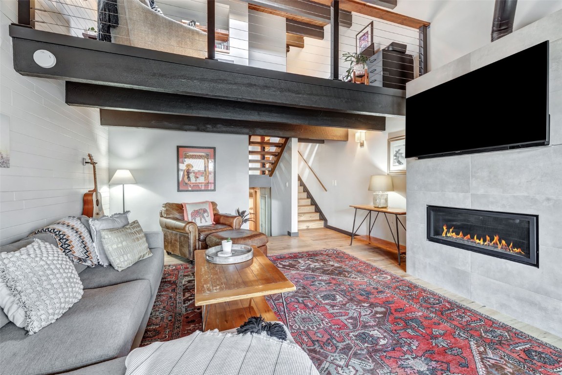 a living room with furniture a flat screen tv and a fireplace