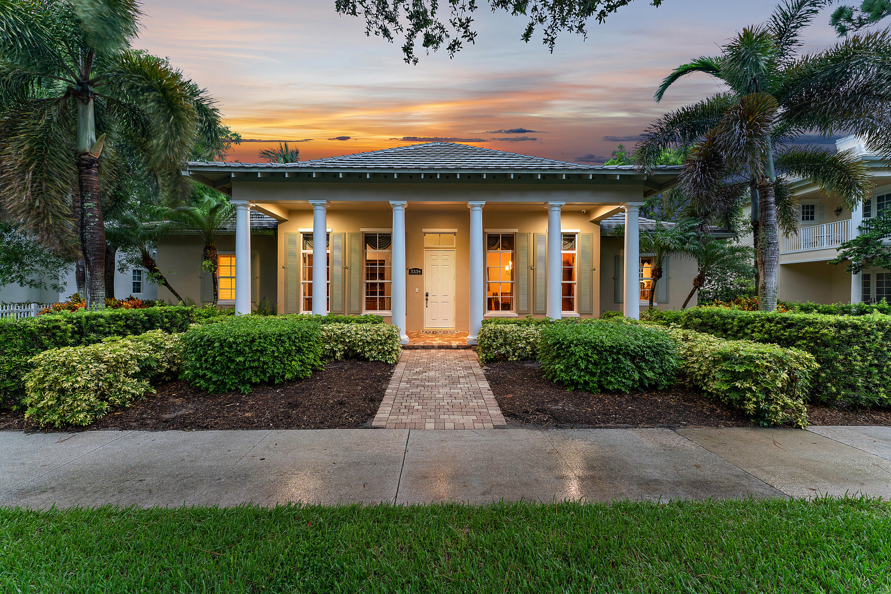 a view of a white house with a yard and potted plants