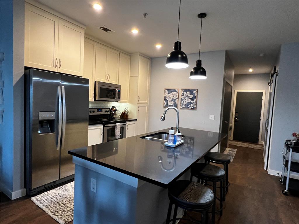 a kitchen with stainless steel appliances granite countertop a sink a refrigerator and a stove