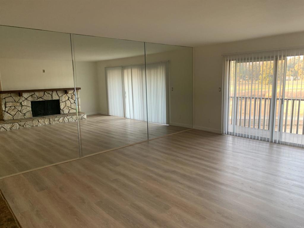 an empty room with wooden floor and fireplace