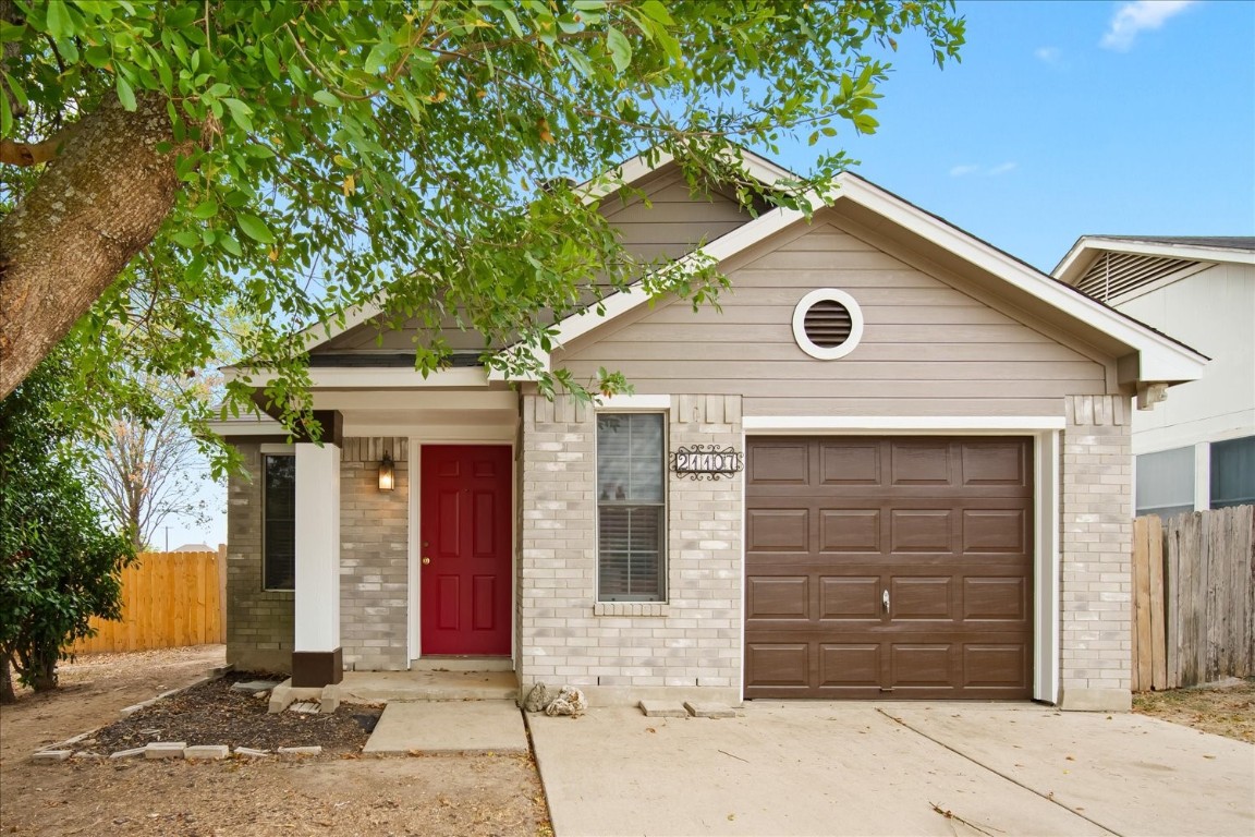 a front view of a house with a tree