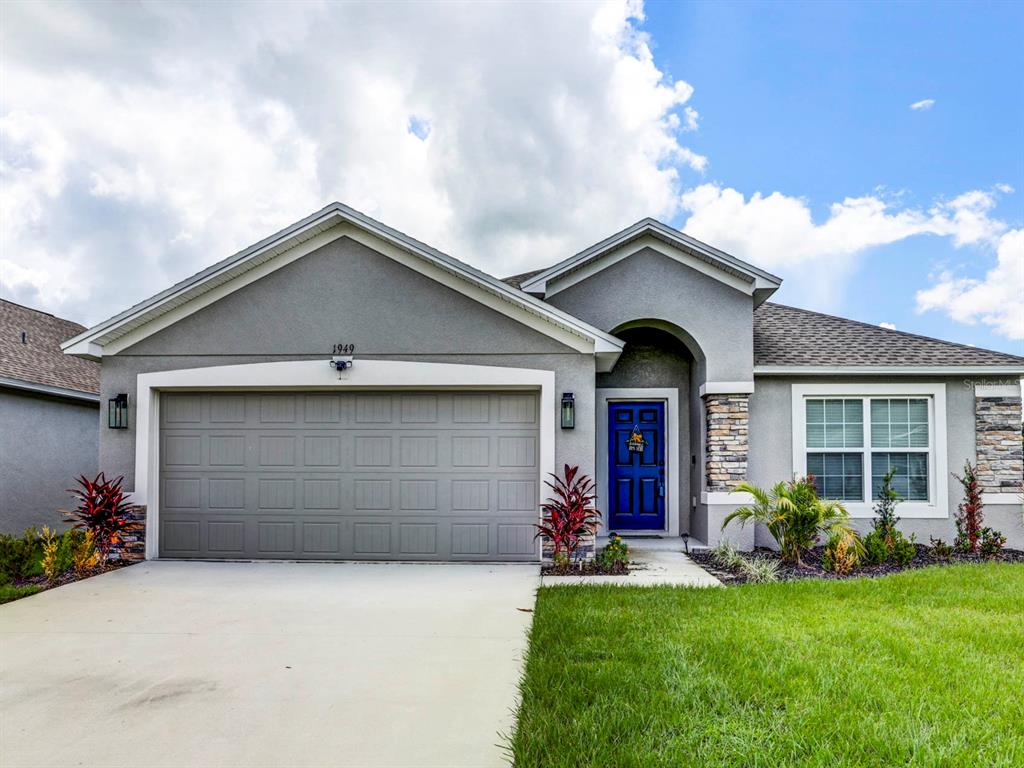 a front view of a house with a yard and garage