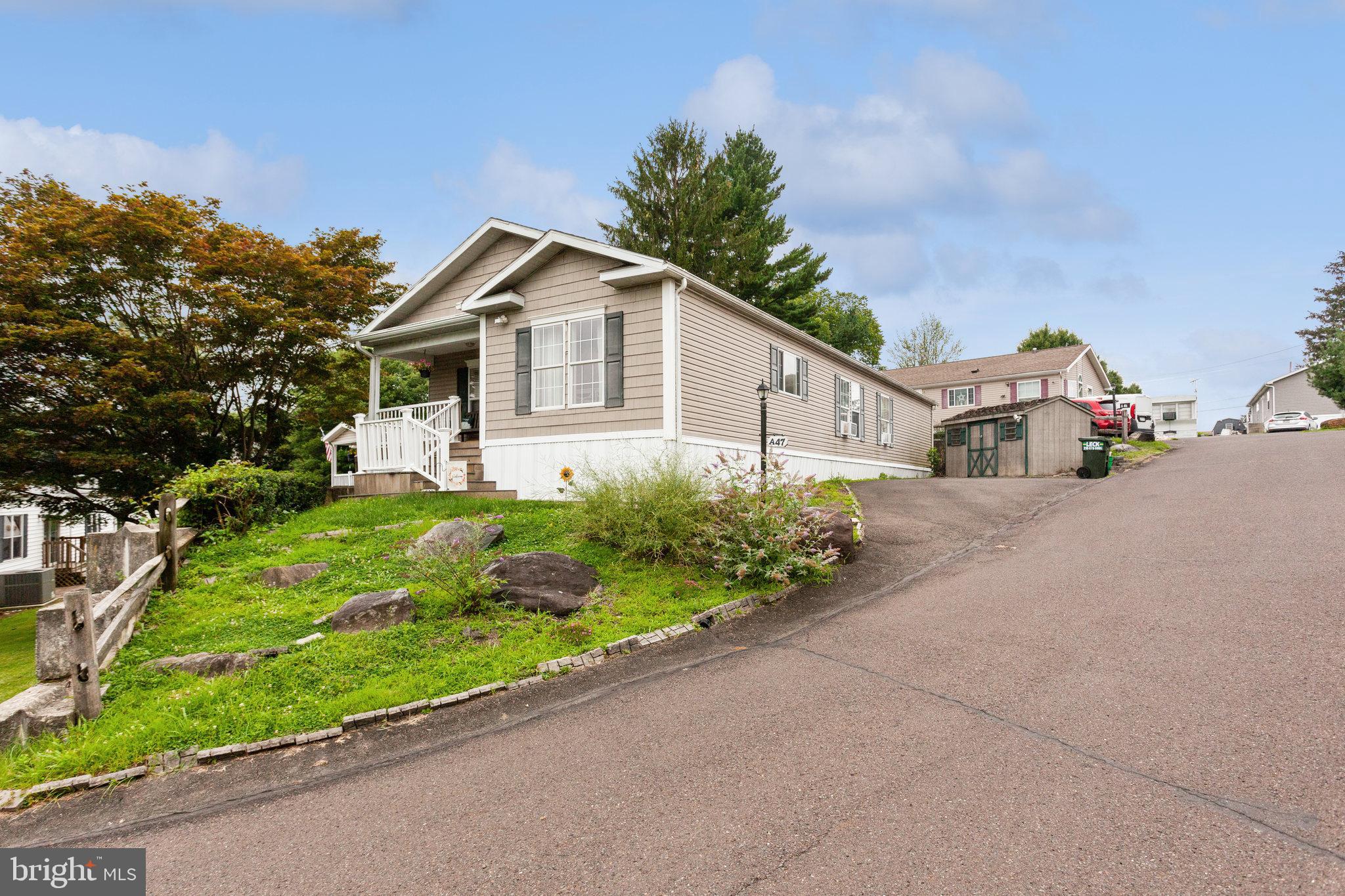 a front view of a house with a yard and potted plants