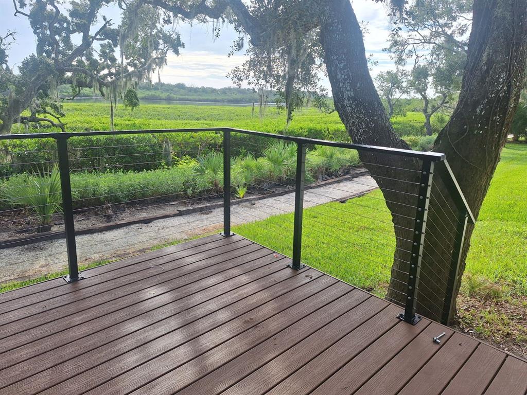 a view of a park with wooden deck and a large tree