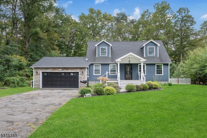 a front view of a house with a garden and yard