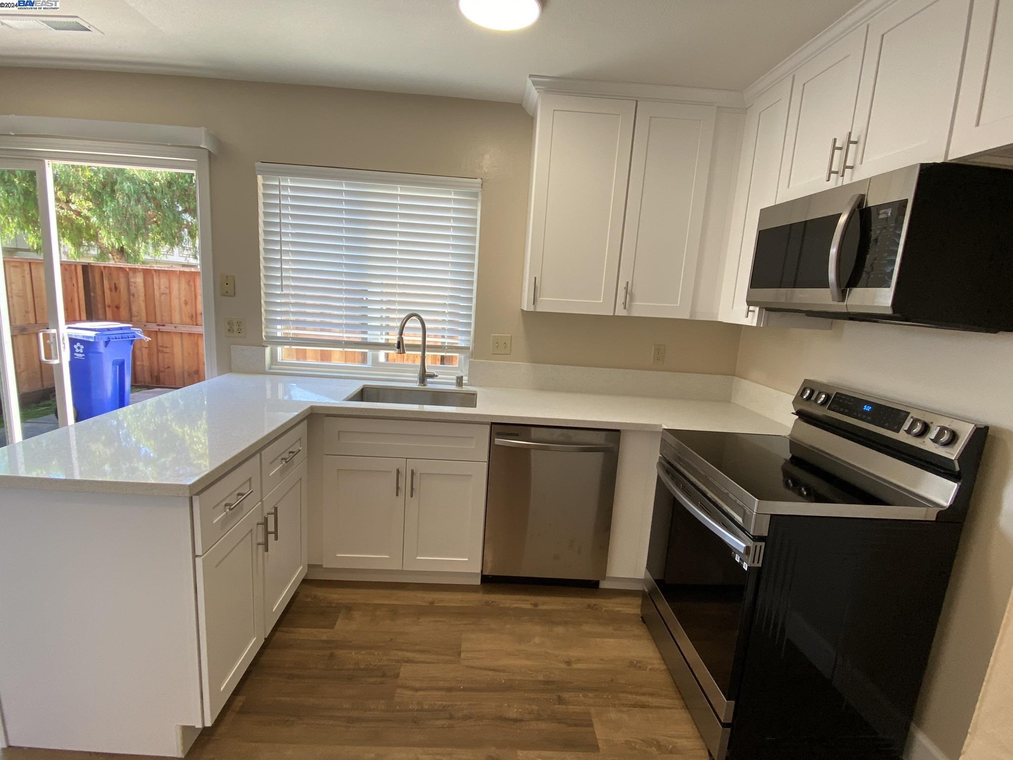 a kitchen with a sink stove top oven and cabinets