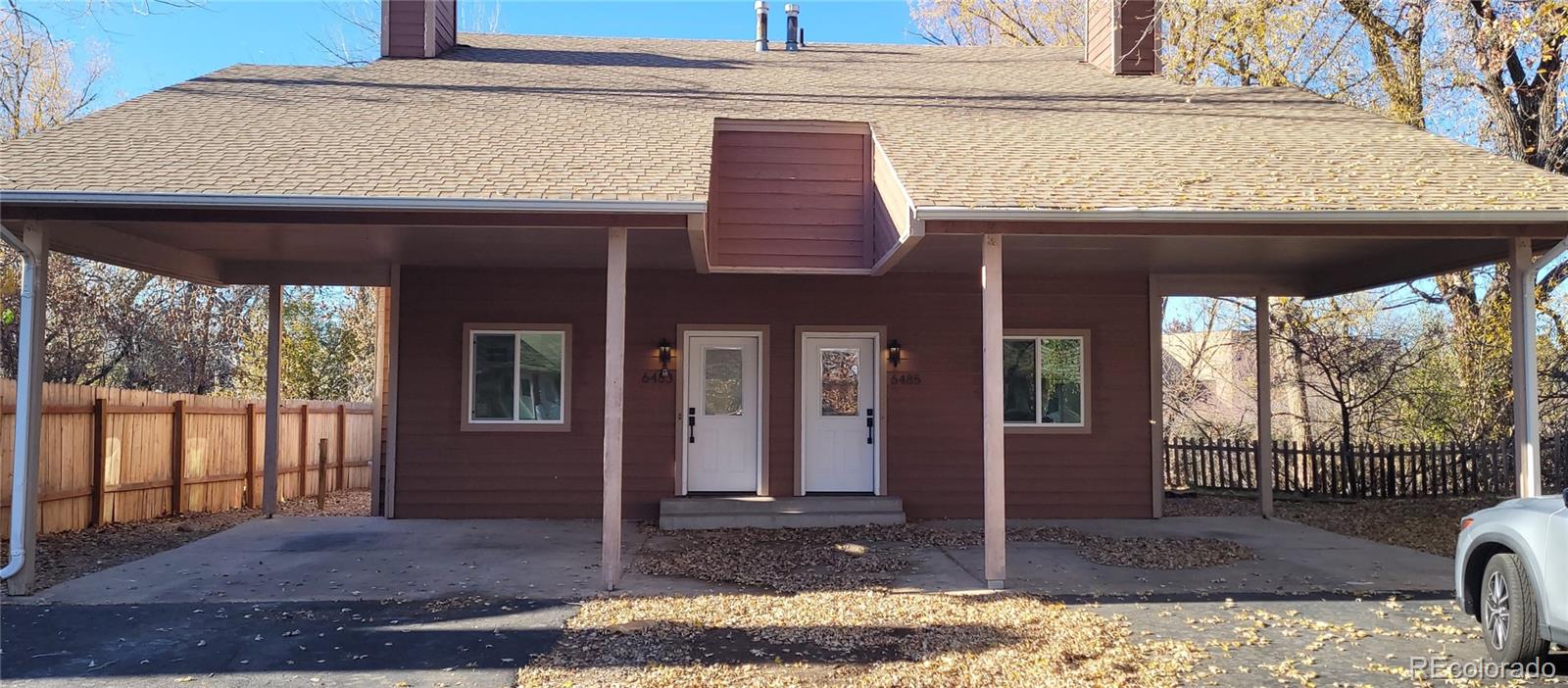 a view of a house with porch next to a yard