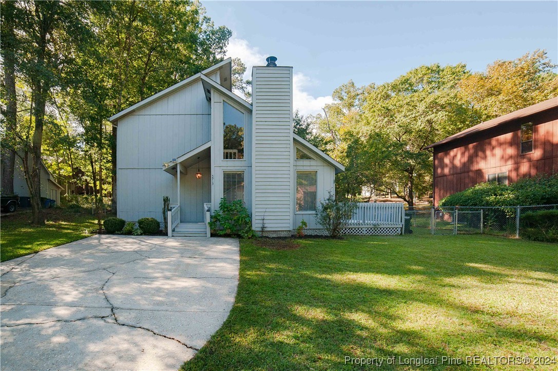 a view of a house with a yard and tree s