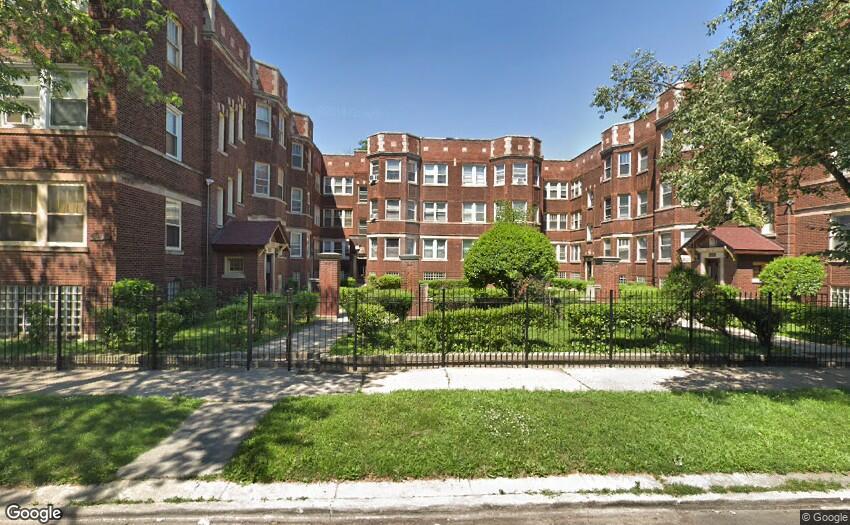 a front view of a residential apartment building with a yard