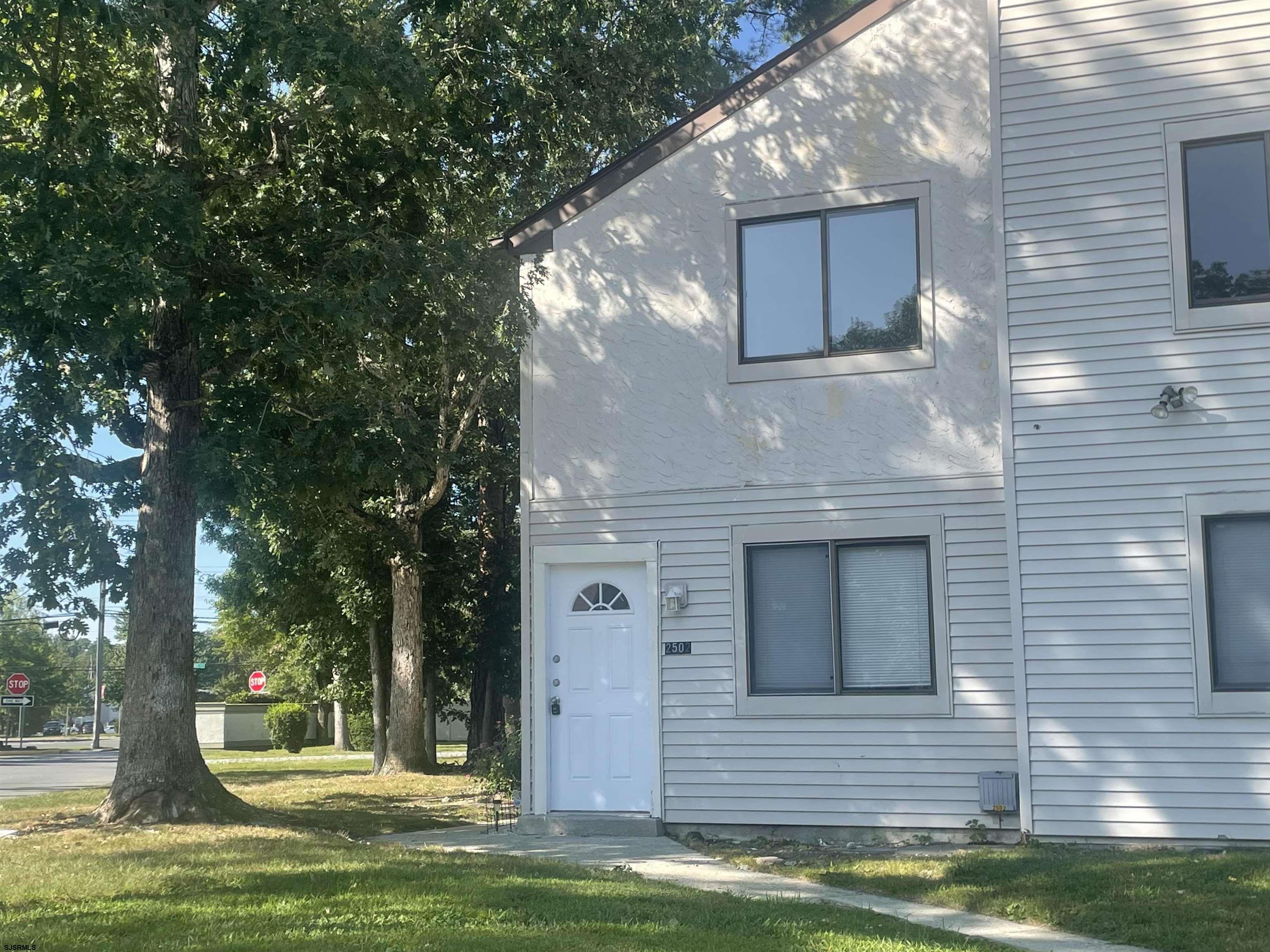 a view of a house with a yard garage and a tree