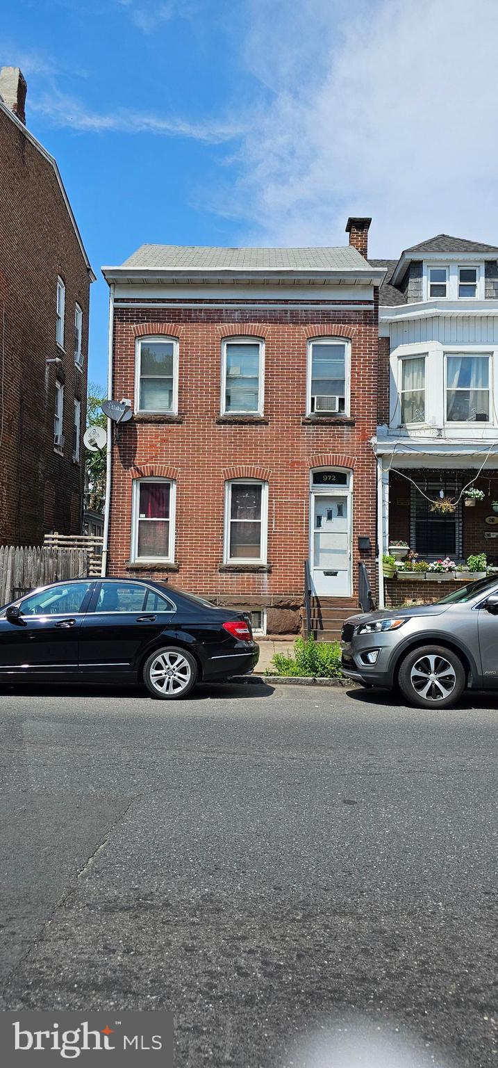 a view of a car parked in front of a brick house