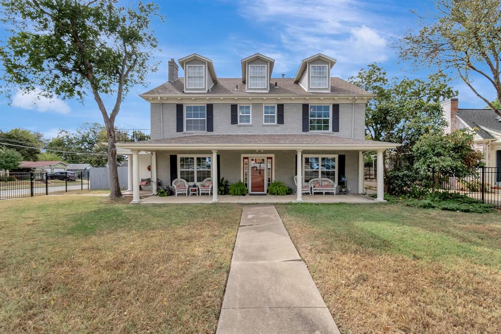 front view of a brick house with a yard