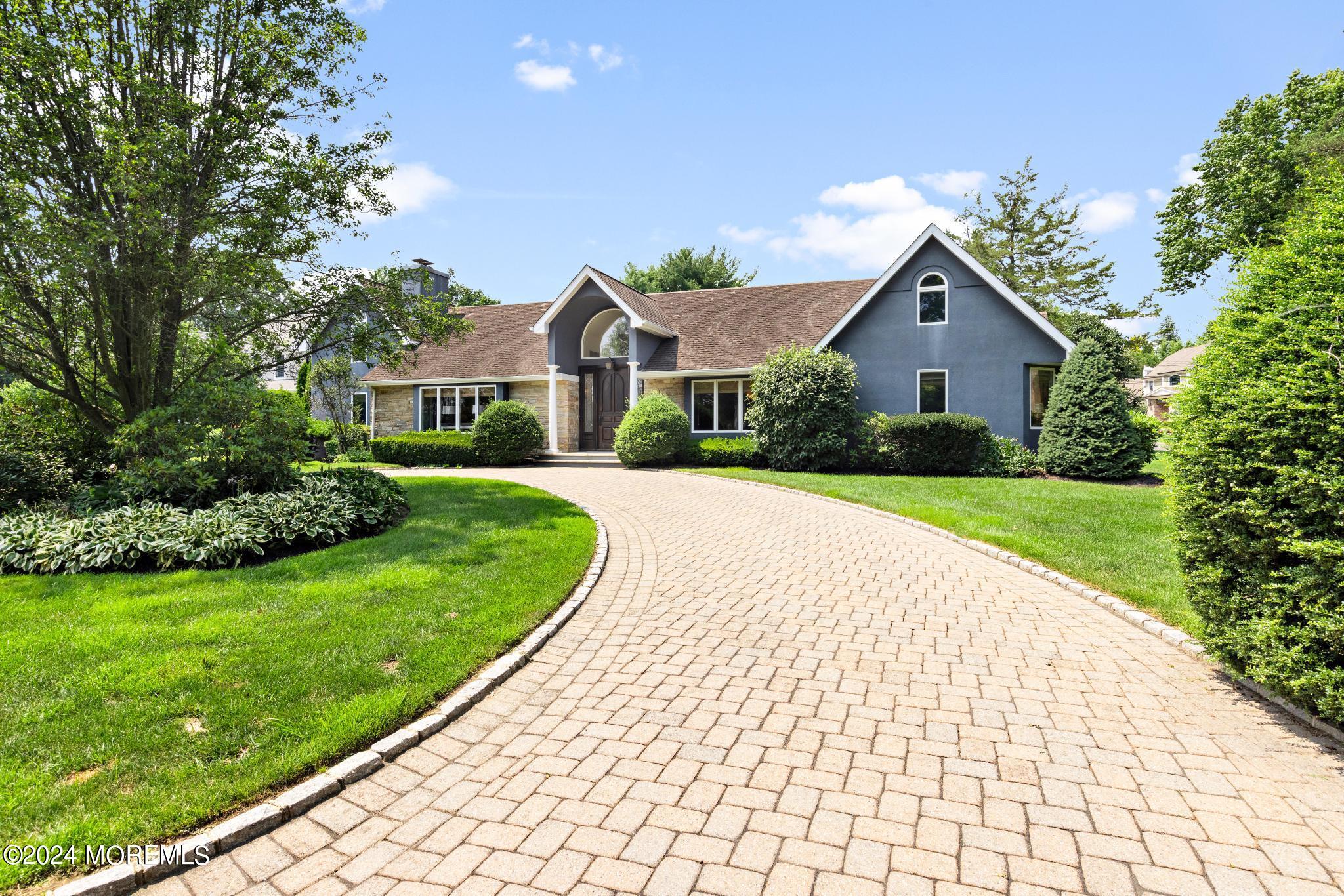 a front view of a house with a yard and potted plants