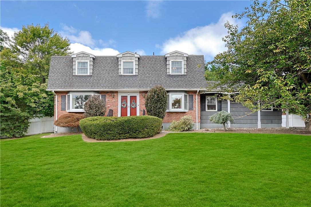 New england style home with a front lawn