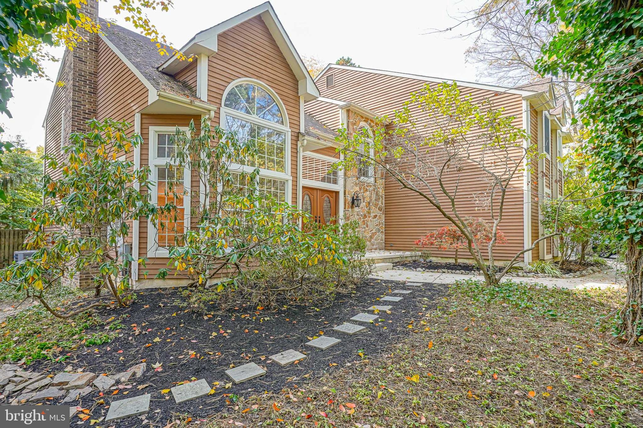 a view of a brick house with a yard and plants