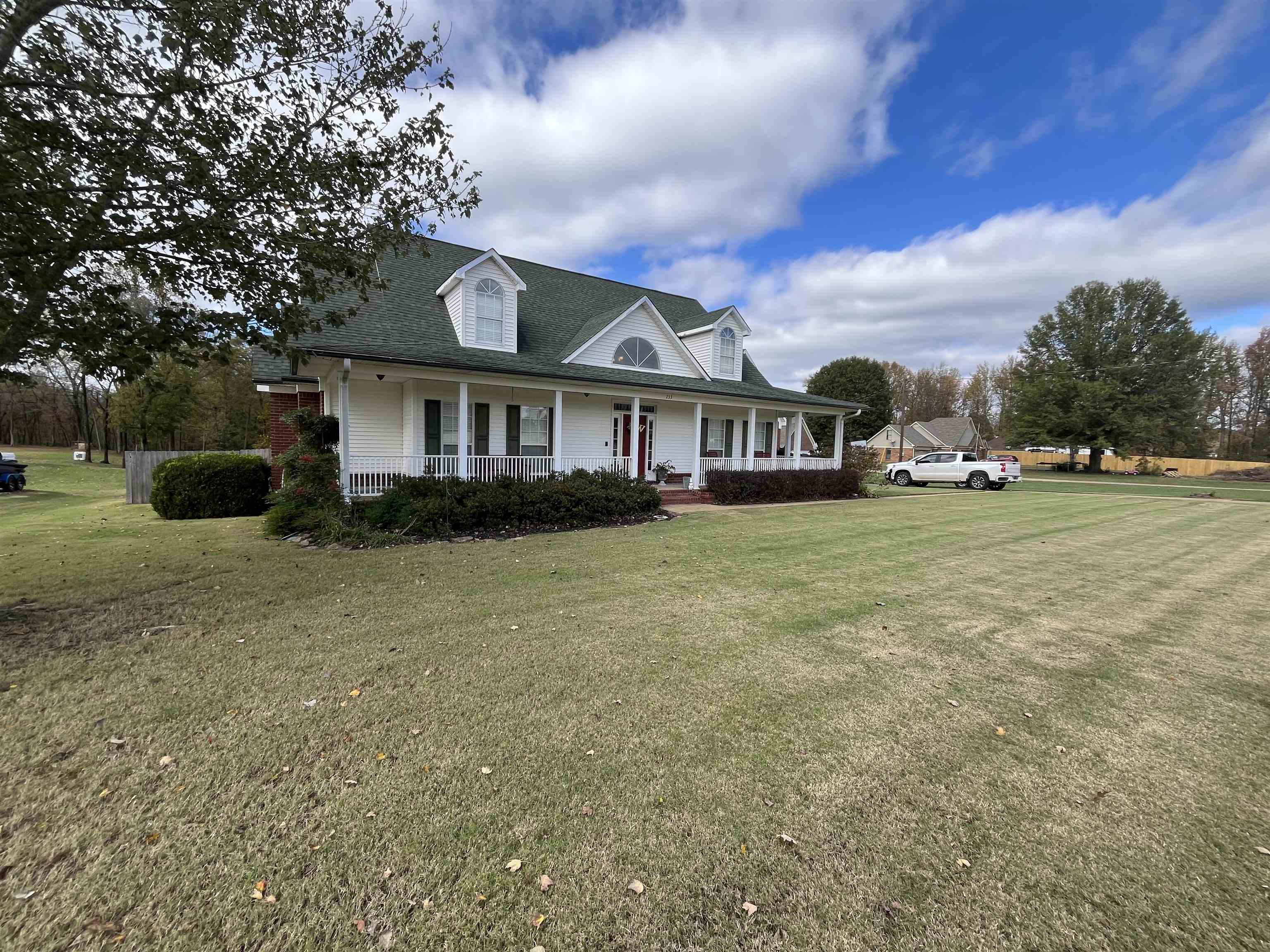 View of front of home featuring covered porch and a front lawn