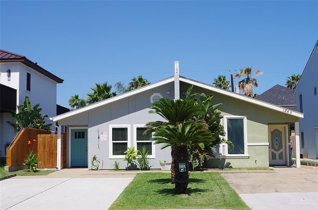 a front view of a house with a yard and potted plants