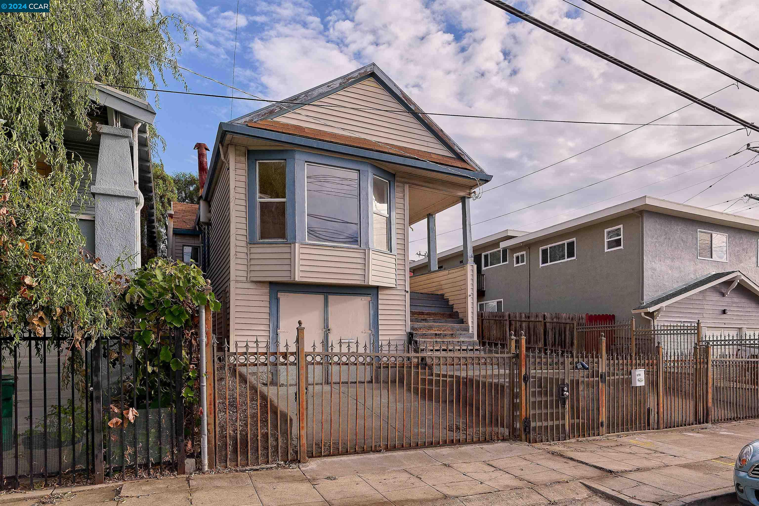 a front view of a house with iron fence