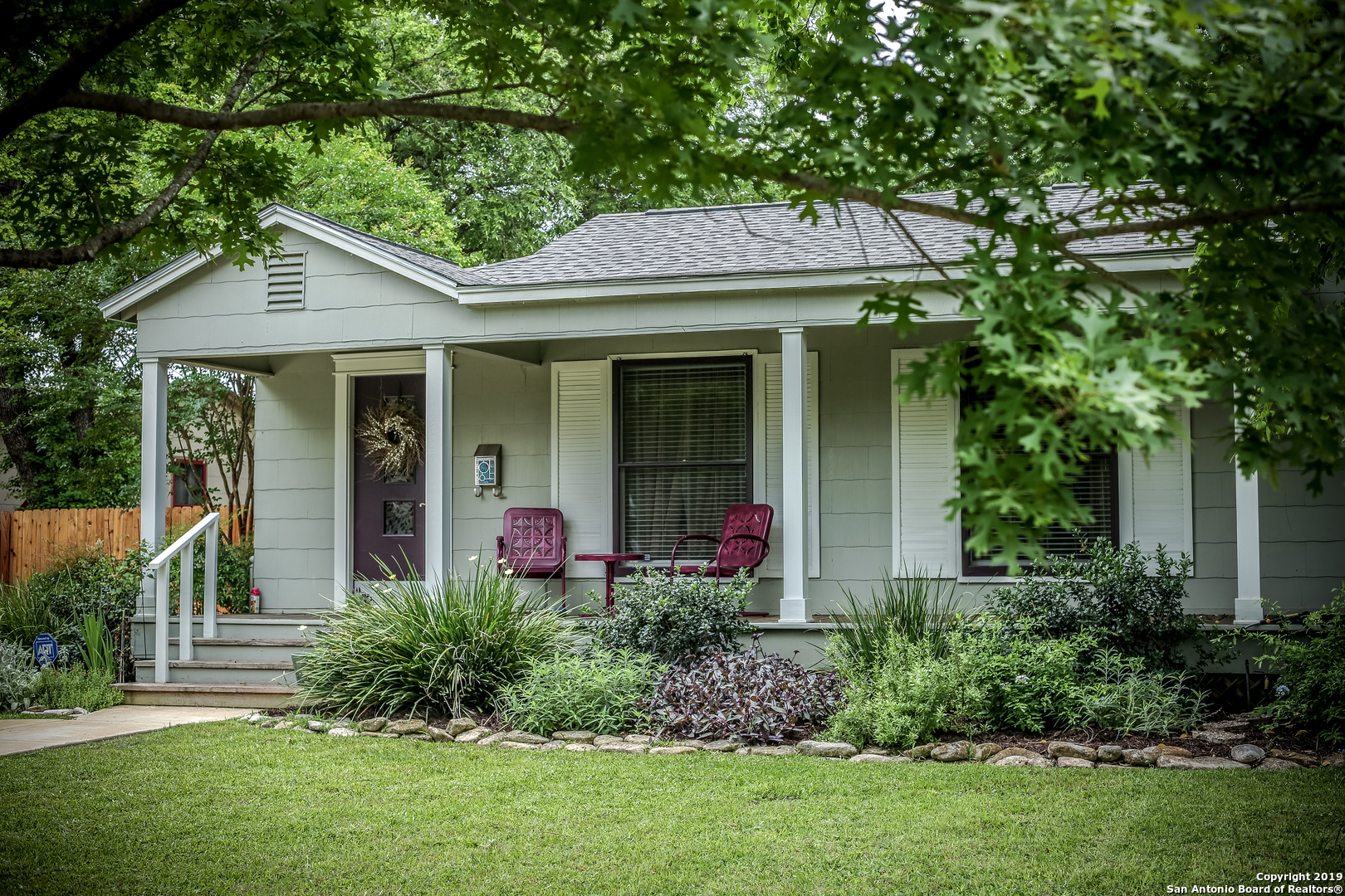 a front view of a house with a garden and plants