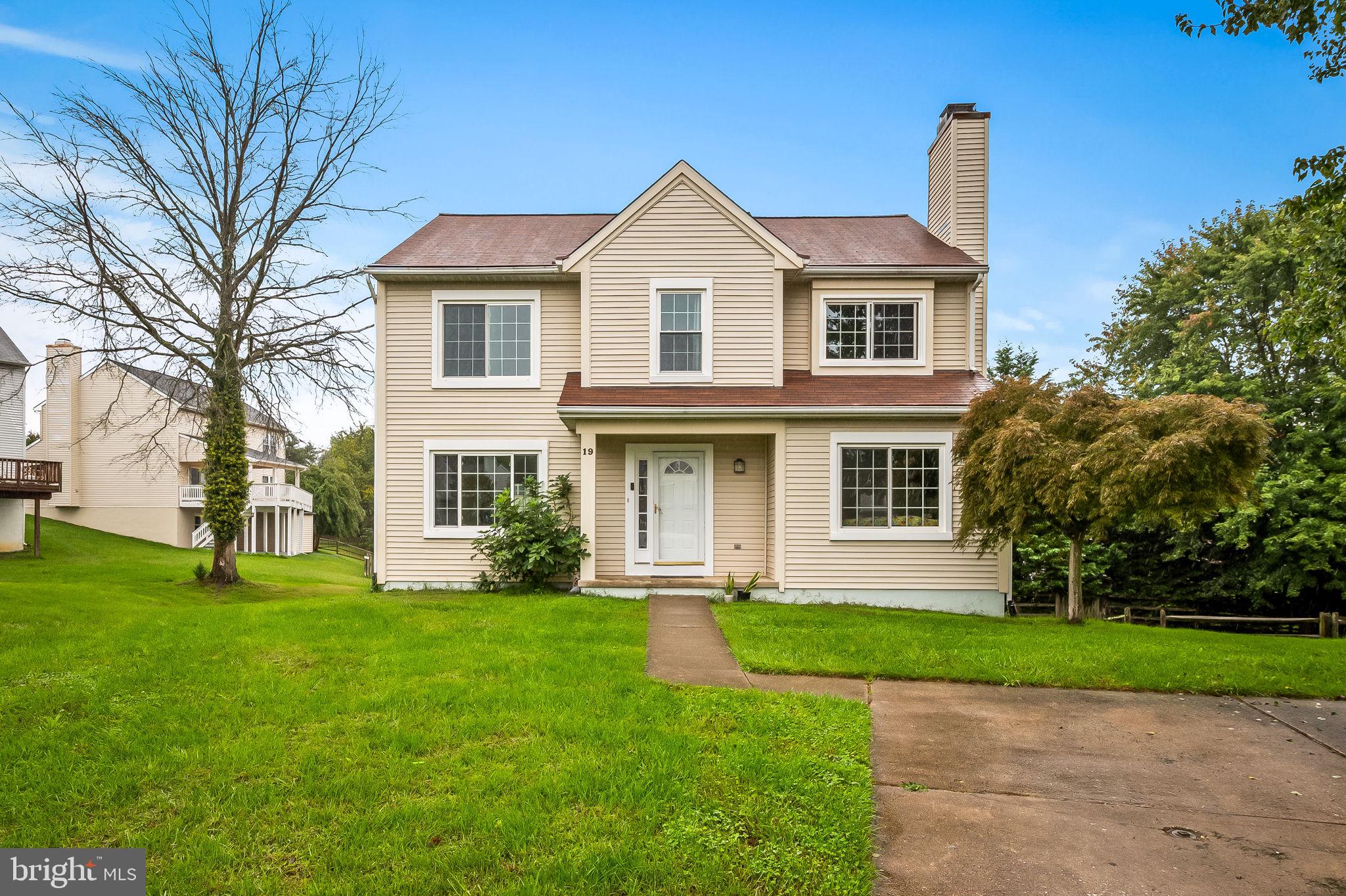 a front view of a house with a yard and trees