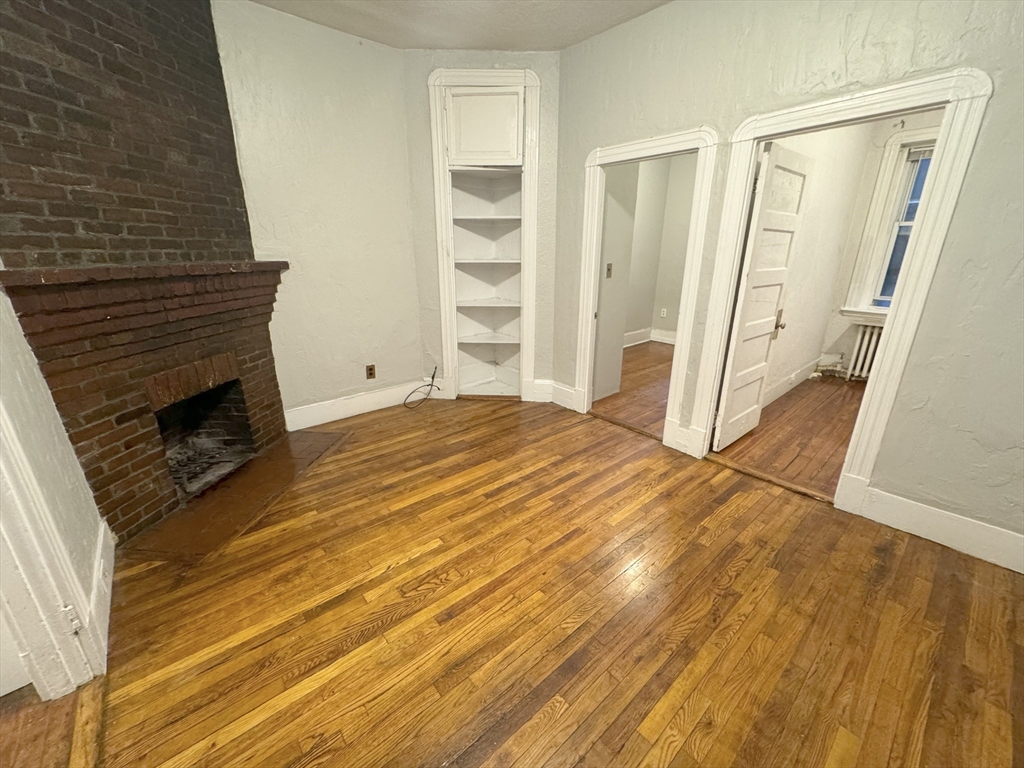 a view of empty room with wooden floor and stairs