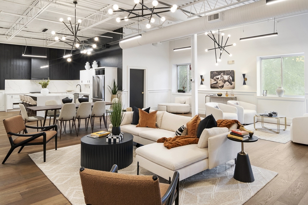 a living room with lots of furniture and view of kitchen