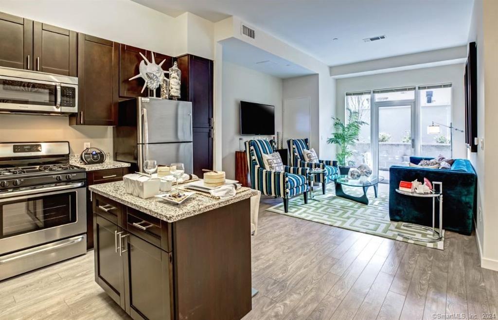 a kitchen with stainless steel appliances granite countertop a stove and a wooden cabinets