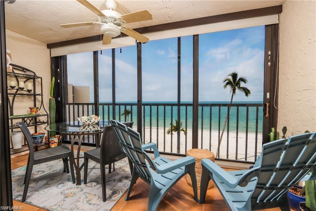 Sunroom / solarium with ceiling fan, a water view, and a view of the beach