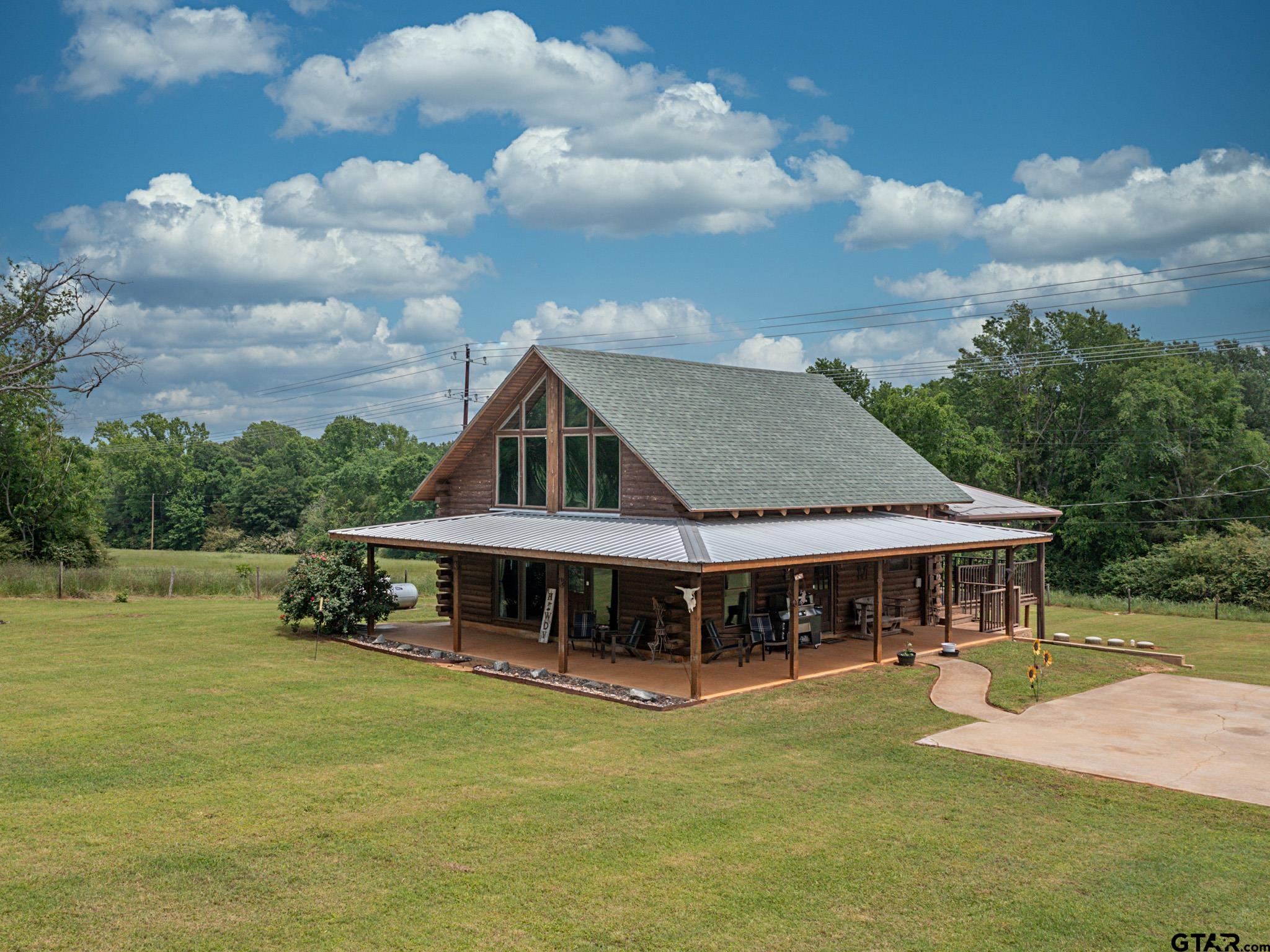 a front view of a house with a garden and swimming pool