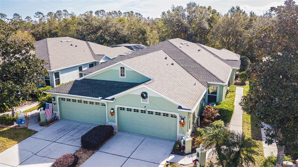 a aerial view of a house with a yard and large tree