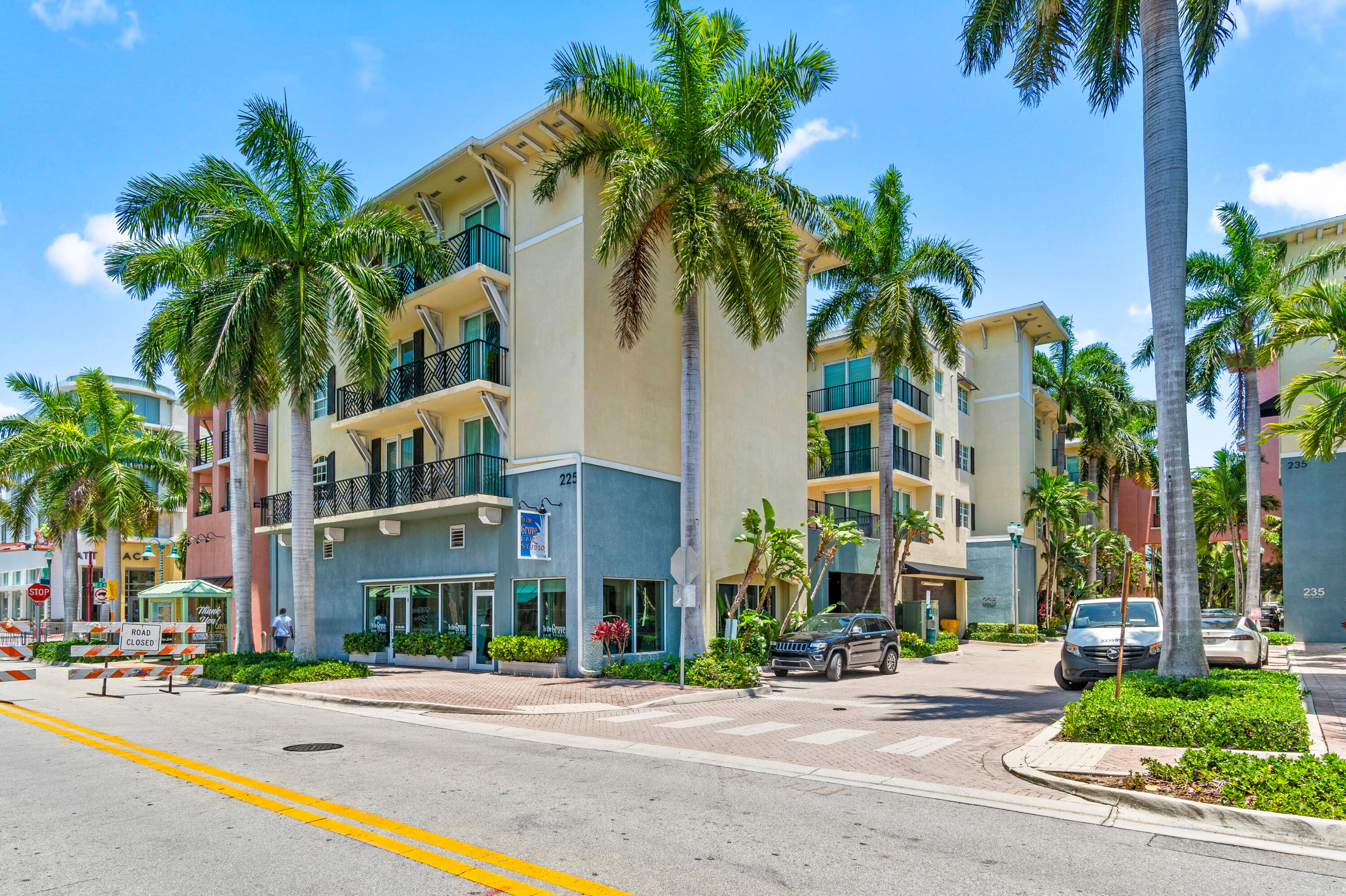 a street lined with buildings and a palm tree