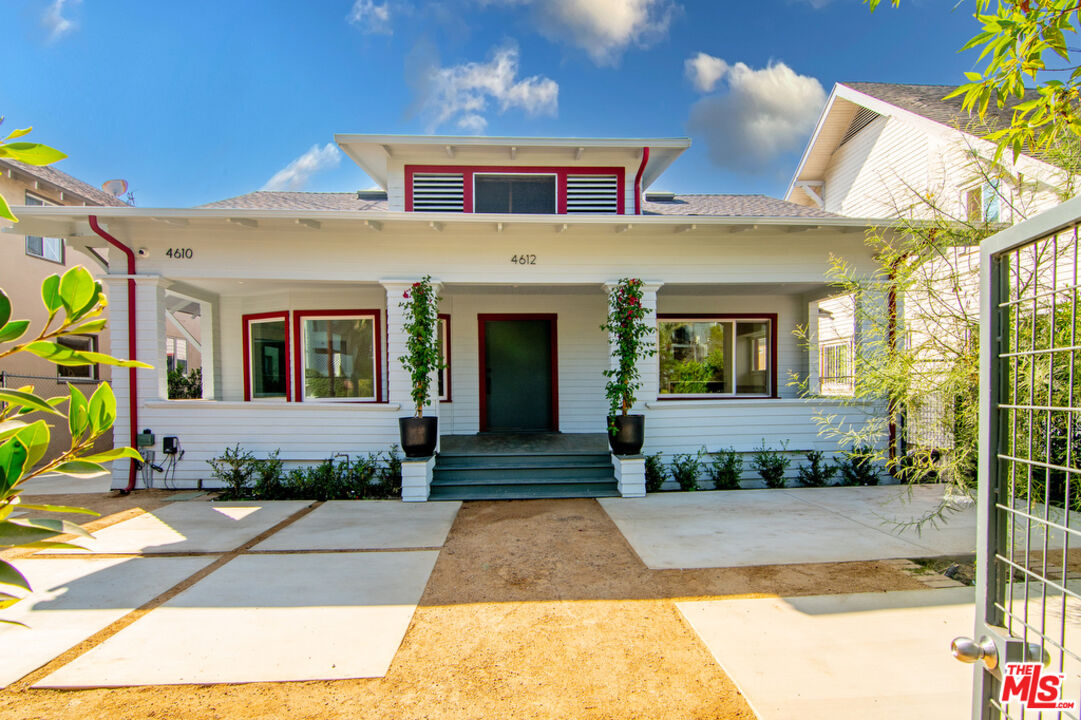 a front view of a house with a yard potted plants