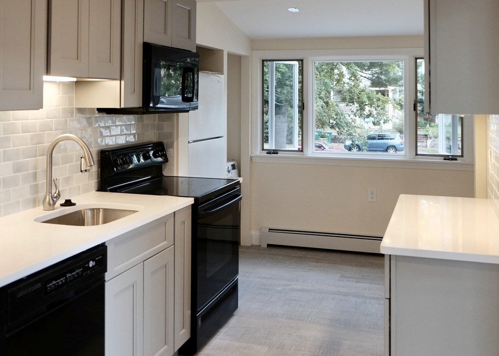 a kitchen with a sink stove and microwave