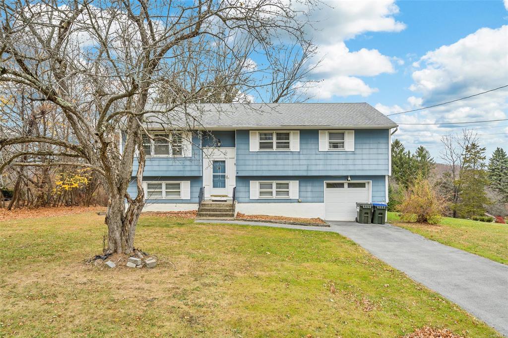 Raised ranch featuring a front yard and a garage