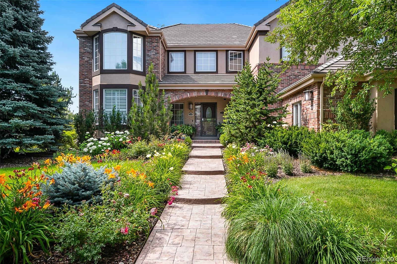 a front view of a house with a yard and potted plants