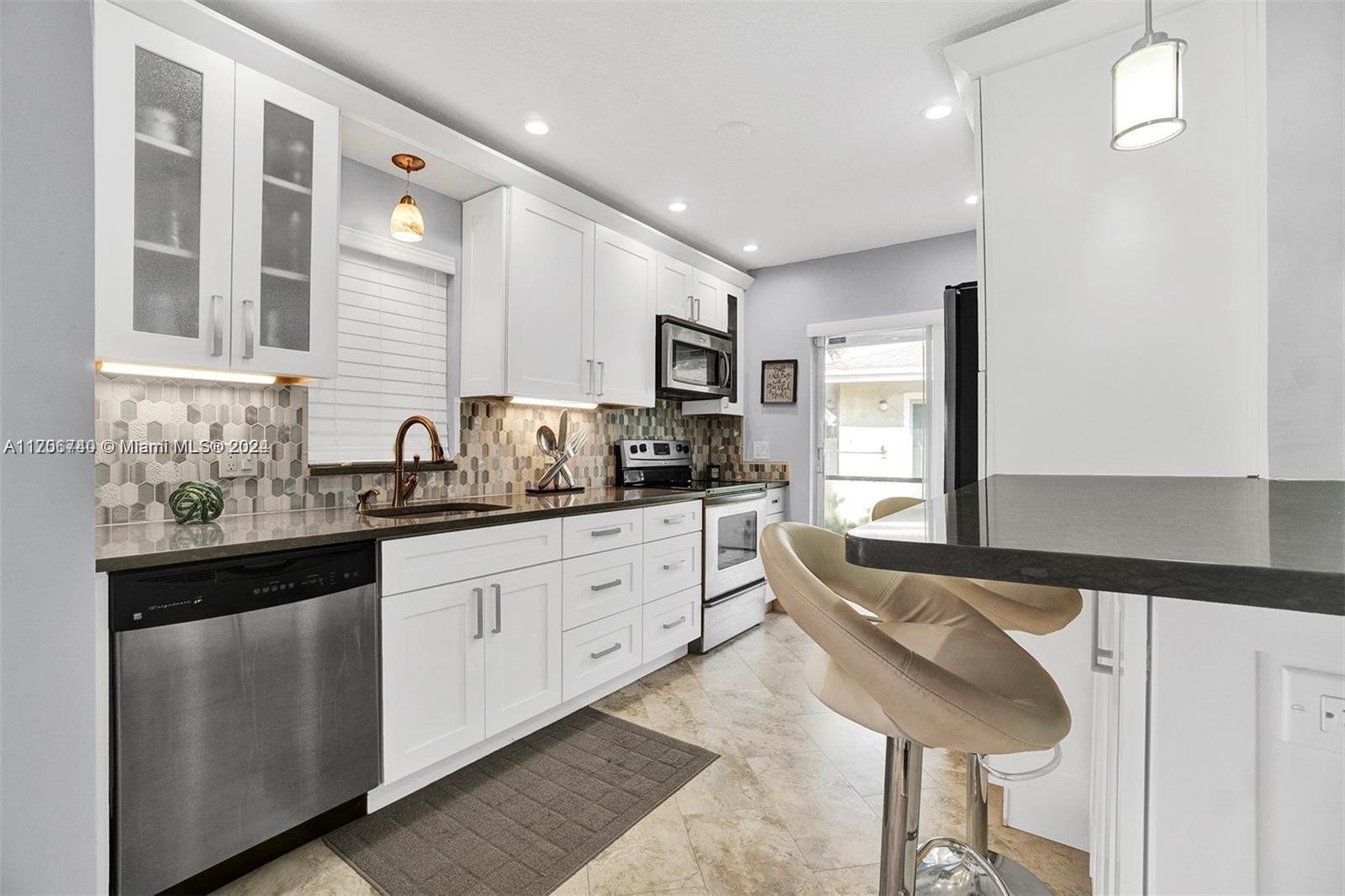 a kitchen with granite countertop a sink and cabinets