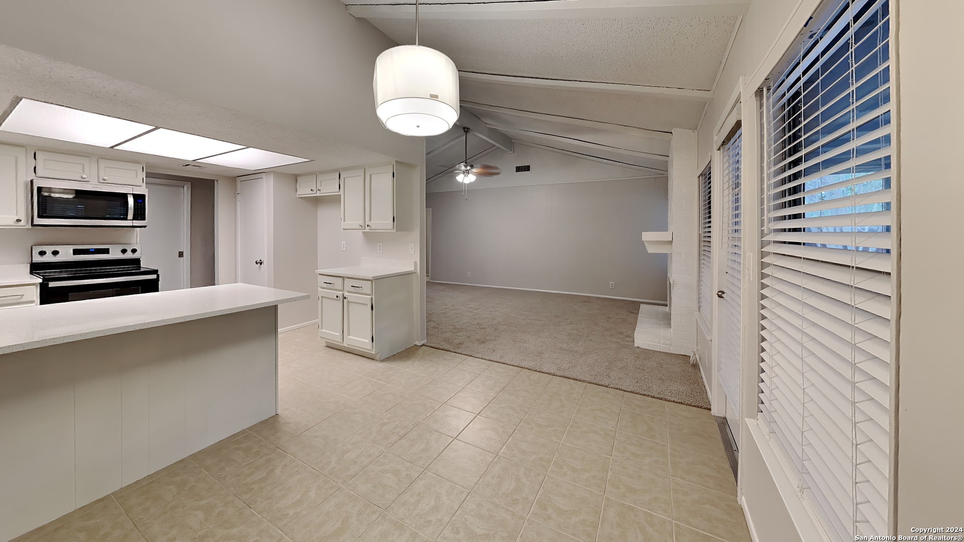 a view of a kitchen with furniture and a ceiling fan