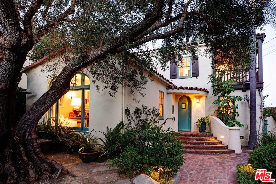 a front view of a house with a tree