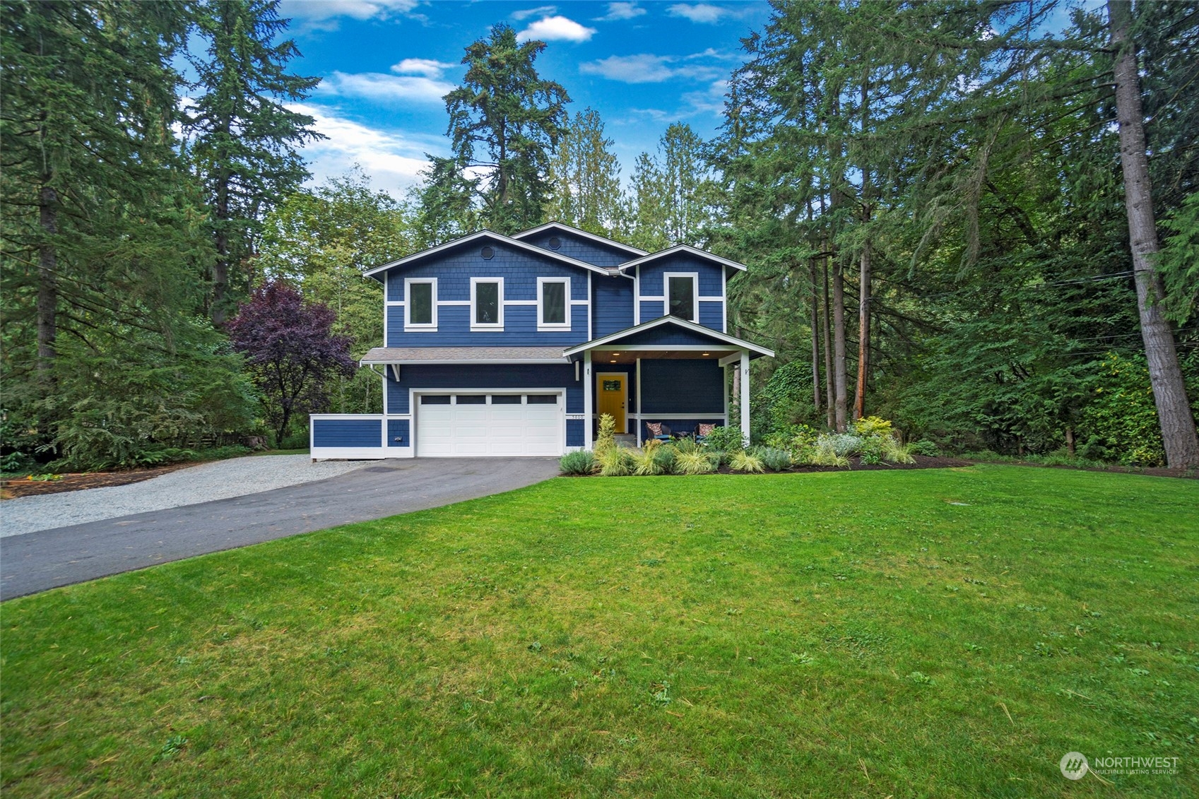 a front view of a house with yard and green space