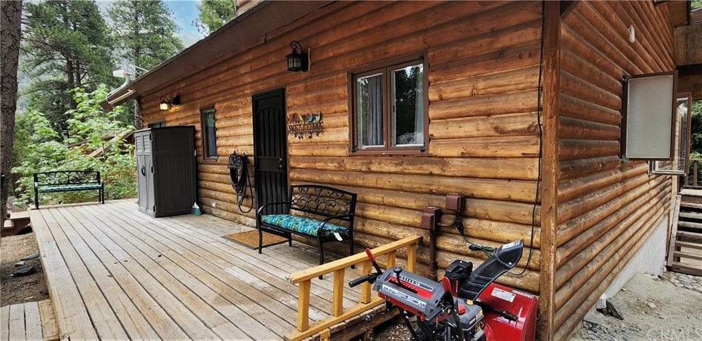 a backyard of a house with wooden floor chairs sofa and barbecue oven