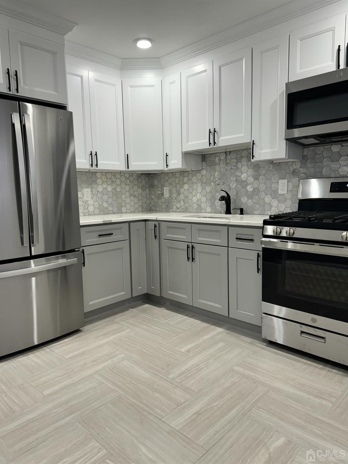 a kitchen with stainless steel appliances granite countertop a stove a refrigerator and a microwave