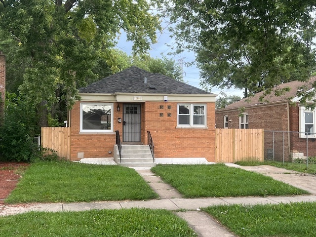 a front view of a house with a garden and yard