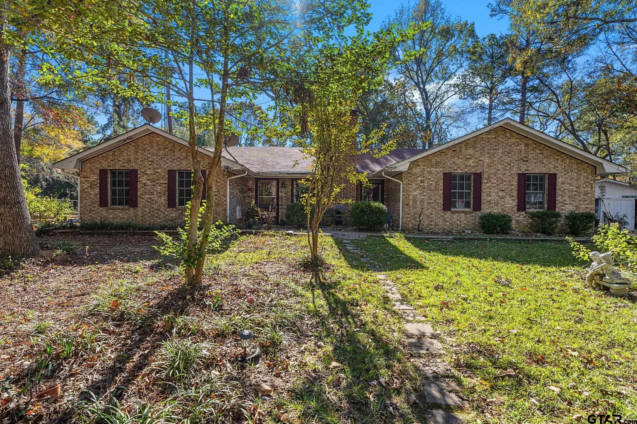 a front view of a house with a yard and trees