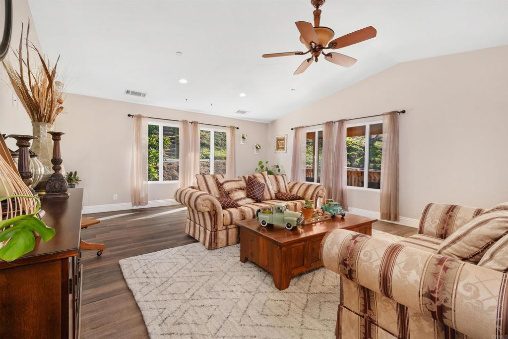 a living room with furniture ceiling fan and a window