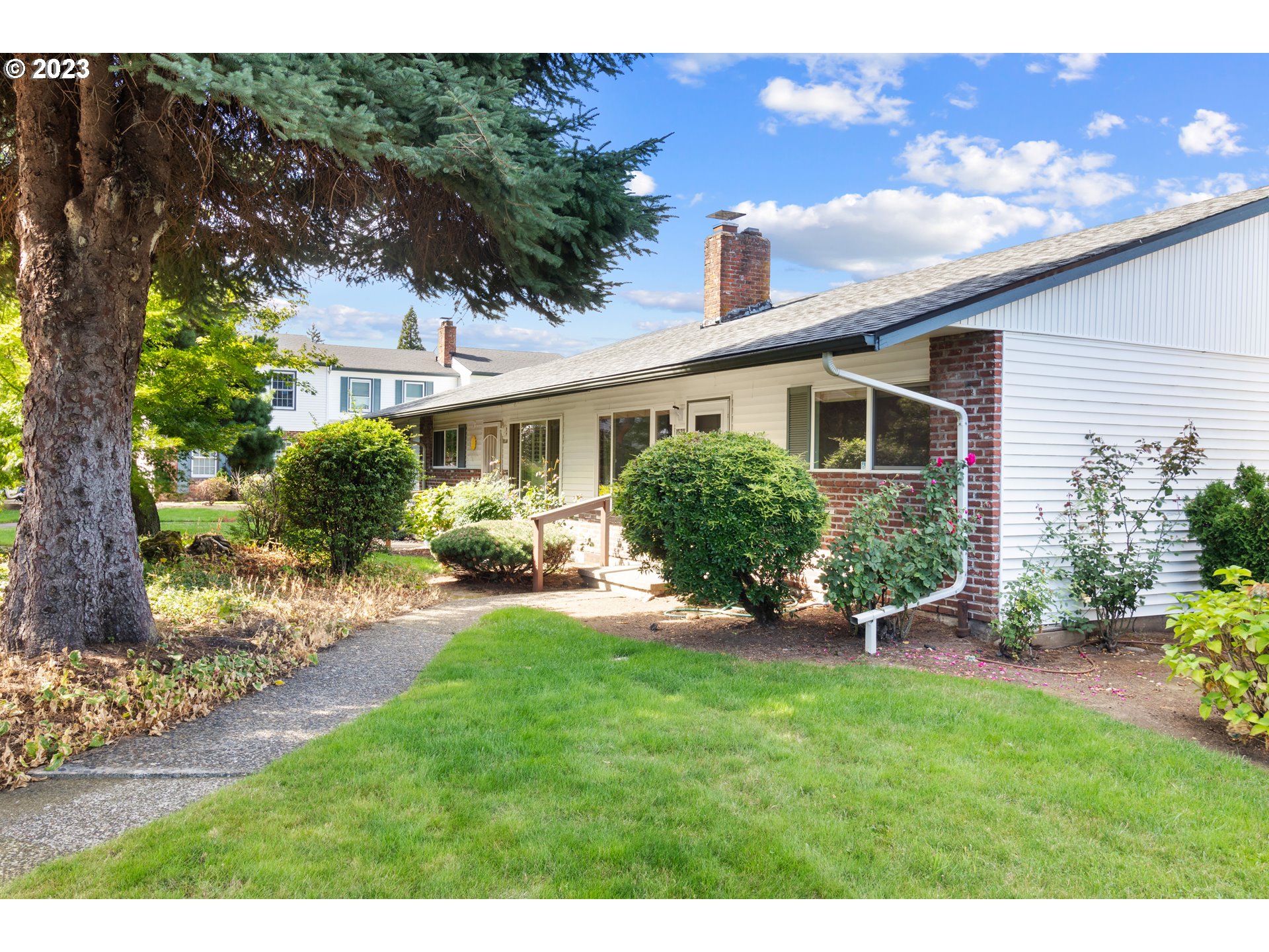 a view of a house with a yard and potted plants