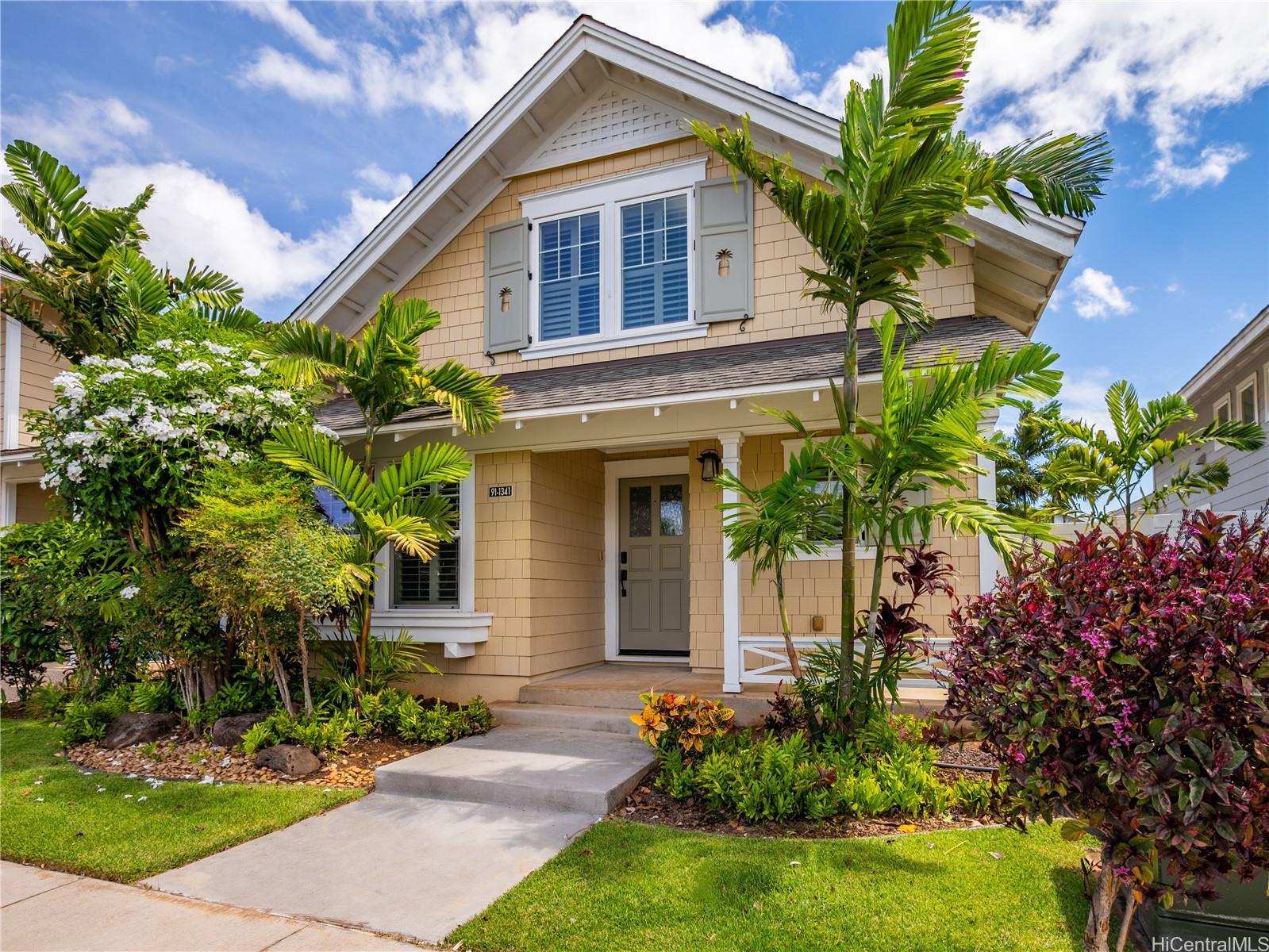 a front view of a house with a yard and potted plants