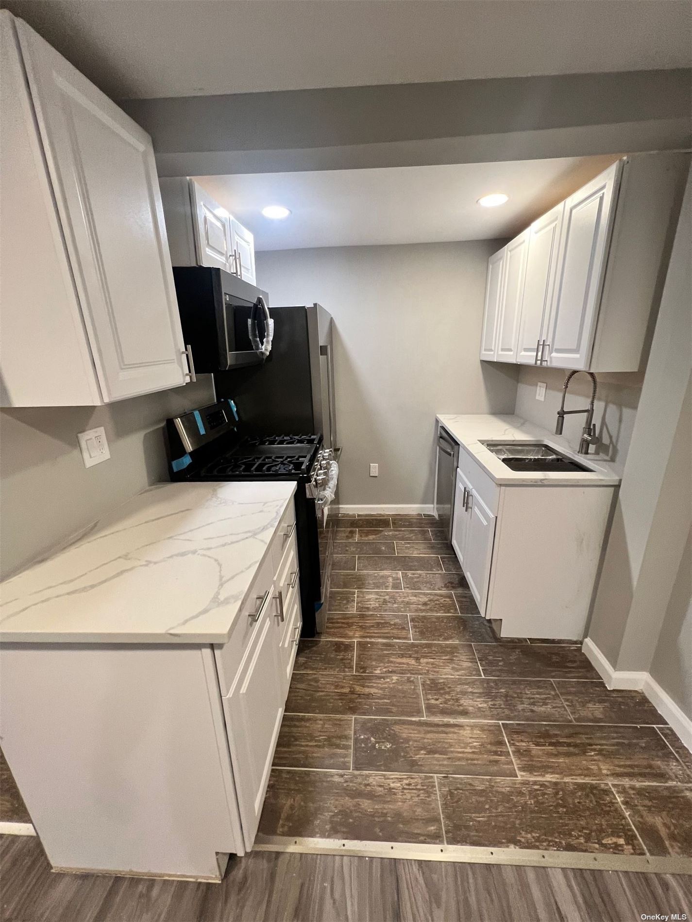 a kitchen with sink stove and refrigerator