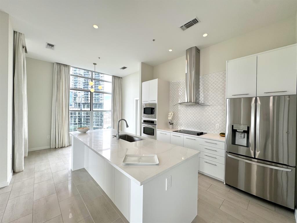 a kitchen with stainless steel appliances granite countertop a sink stove and refrigerator