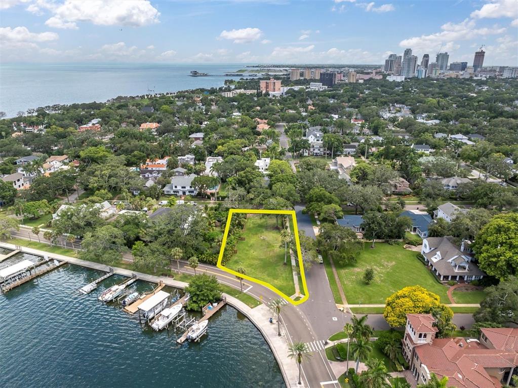 an aerial view of a residential houses with outdoor space and a lake view