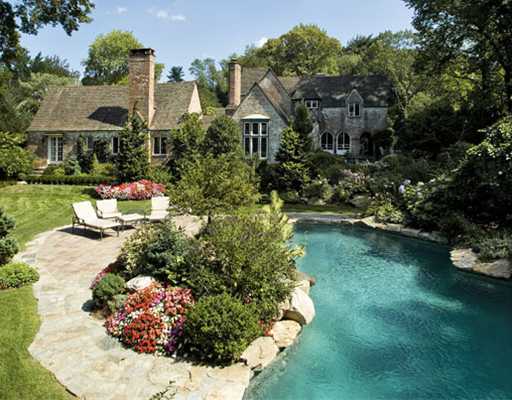 a front view of a house with a yard and fountain